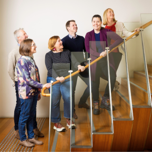 6 graduates from 2024 Tasmanian Leaders Program on a wooden staircase. All smiling happily and looking up the stairs. Two men and four women are in the photo.