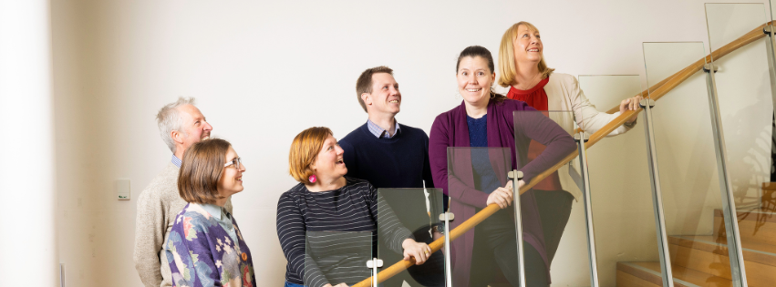 6 graduates from 2024 Tasmanian Leaders Program on a wooden staircase. All smiling happily and looking up the stairs. Two men and four women are in the photo.