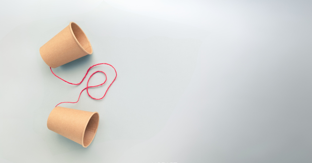 Marketing image background for the Faciliating Dialogue report. A pair of brown coffee cups are linked by a red string ( like a tin can telephone_