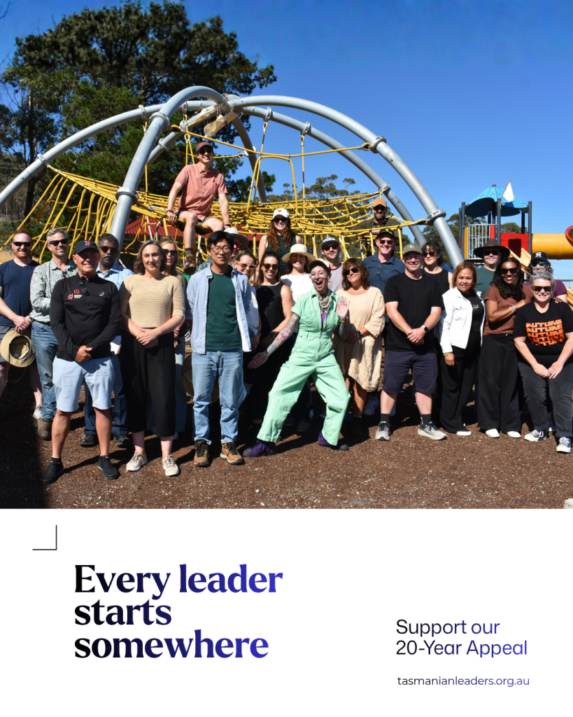 A diverse group of Tasmanian Leaders participants pose together outdoors in front of a playground climbing structure. Text reads: “Every leader starts somewhere. Support our 20-Year Appeal.”