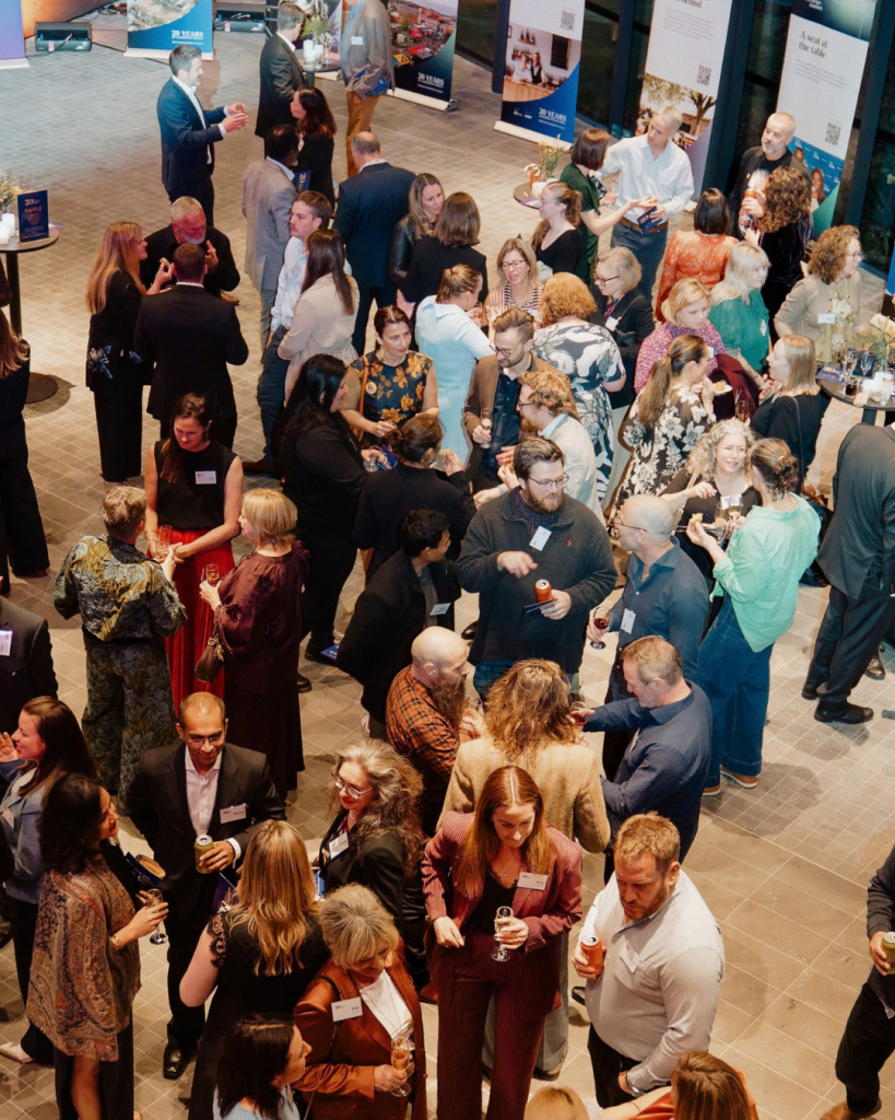Overhead view of attendees gathered in small groups, talking and socialising at a Tasmanian Leaders networking event.