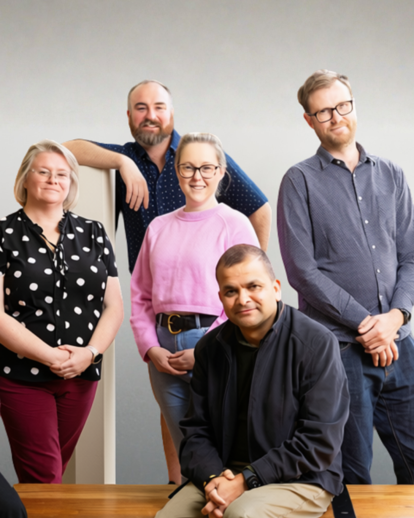 Five Tasmanian Leaders participants pose together indoors, smiling at the camera, with three standing at the back and two in front.