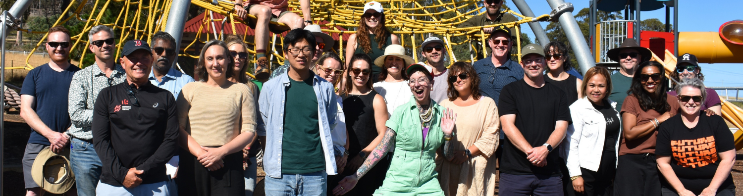 A group of Tasmanian Leaders participants stand in a group in front of a playground